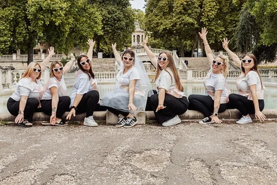 groupe de femmes celebrant posees devant une fontaine levant les bras