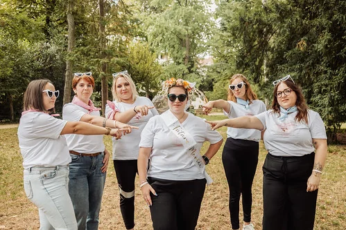 groupe de femmes celebrant dans un parc avec la mariee au centre