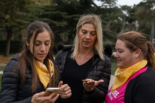 Trois femmes regardant un téléphone pendant une chasse au trésor EVJF à Nantes dans un parc