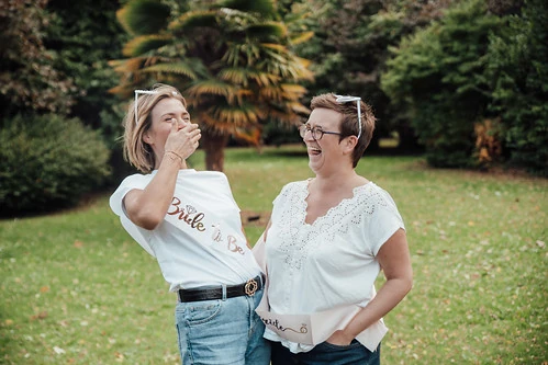 Deux femmes rient ensemble dans un parc verdoyant