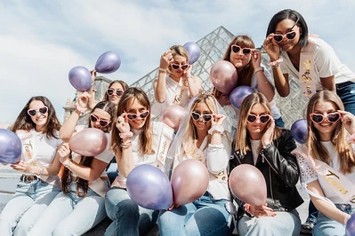 groupe de femmes celebrant un evjf a paris avec des ballons devant le louvre