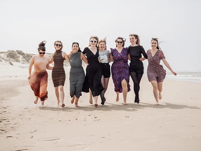 shooting photo evjf strasbourg groupe de femmes courant sur la plage en tenue elegante lors d’un evjf au touquet paris plage