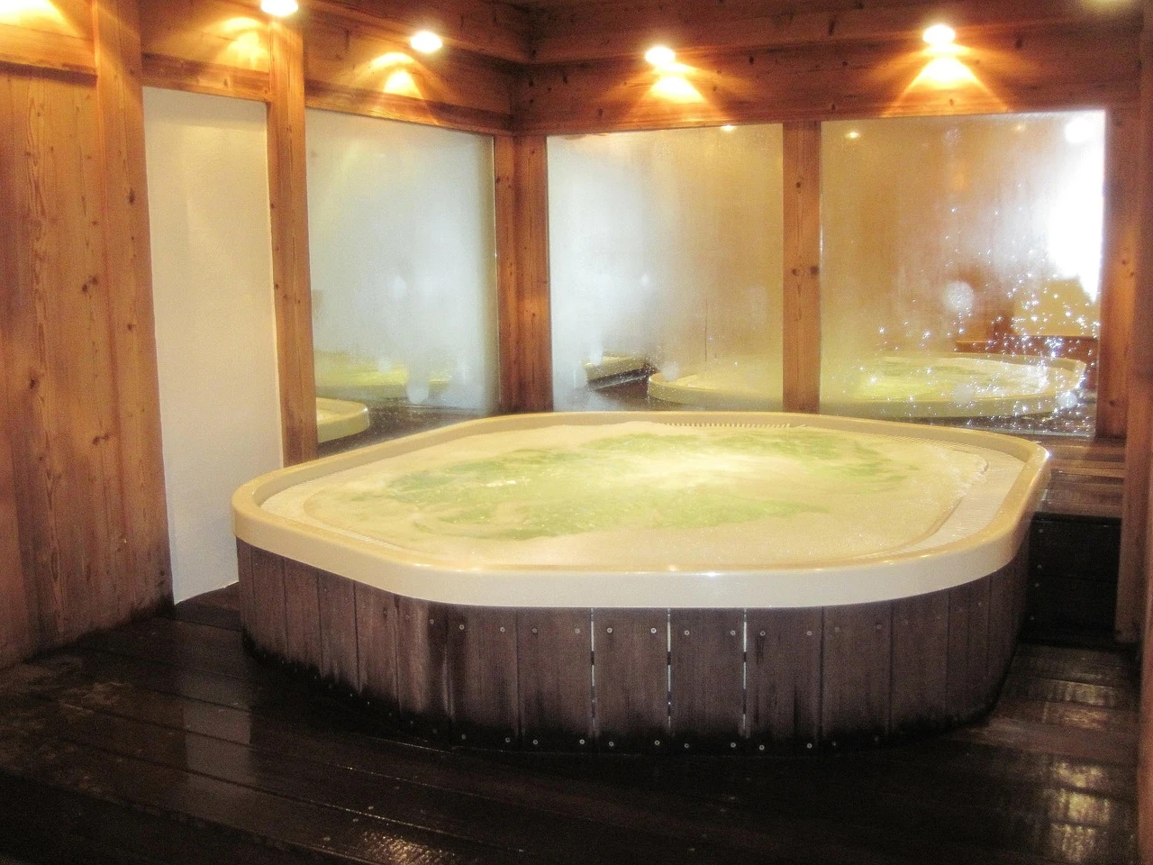 jacuzzi en bois dans une pièce chaleureuse éclairée
