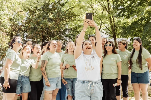 groupe de femmes riant et prenant un selfie dans un parc verdoyant