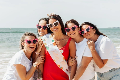 groupe de femmes souriantes portant des lunettes roses en forme de cœur lors d’une chasse au trésor evjf à la baule