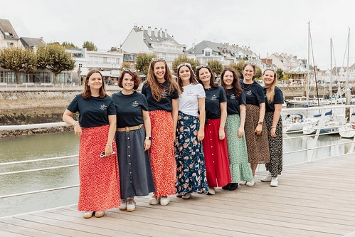 groupe de femmes souriantes en jupe colorée posant sur un ponton lors d’une chasse au trésor evjf à la baule