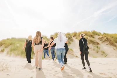 groupe de femmes marchant dans les dunes pendant une chasse au trésor evjf touquet paris plage