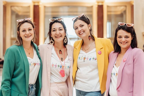 groupe de femmes souriantes en tenue coloréedans un lieu élégant