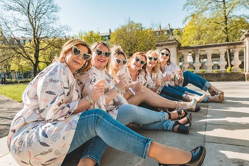 groupe de femmes celebrant un evjf a dijon assises dans un parc ensoleille
