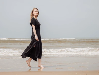 femme en robe noire marchant pieds nus sur la plage du touquet paris plage pendant un clip vidéo evjf