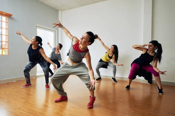 Groupe de femmes suivant un cours de danse EVJF à Biarritz dans une salle lumineuse, ambiance dynamique et conviviale.