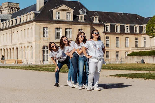 quatre femmes en t shirts blancs posant devant une abbaye pendant des defis et gages evjf à cabourg