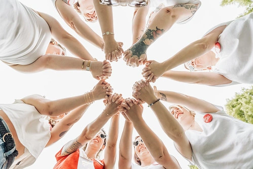 groupe de femmes se tenant les mains en cercle vu du dessous lors d’un evjf à caen