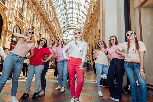 groupe de femmes portant des lunettes de soleil posant ensemble dans une galerie marchande à milan pour un evjf
