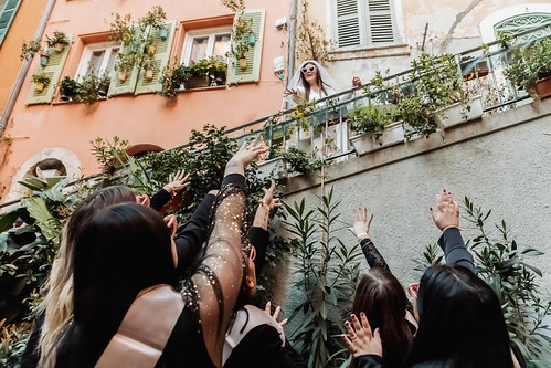 un groupe de femmes lève les bras vers une amie sur un balcon lors d’un evjf à nice