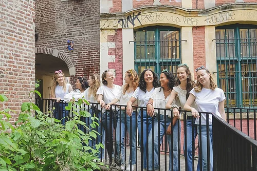 Groupe de femmes souriantes en jeans et t-shirts blancs posant dans une rue du centre-ville de Lille lors d’un EVJF