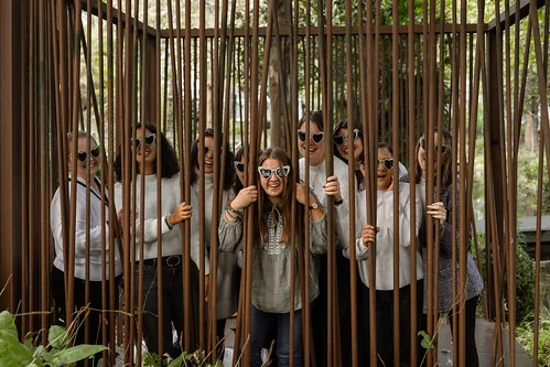 escape-game-evjf-lille-photo-originale Groupe de femmes souriantes derrière des barreaux simulant une cage