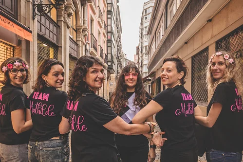 Groupe de femmes portant des t-shirts “Team Mariée” posant dans une rue du centre-ville de Bilbao pendant un EVJF.