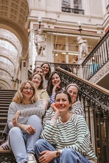 groupe de femmes souriantes assises sur un escalier pendant un evjf à nantes