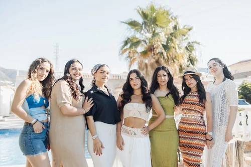 Groupe de femmes élégantes posant près d’une piscine à Marbella pendant un EVJF sous le soleil d’Andalousie.
