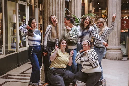 groupe d amies en mariniere riant et posant dans une galerie couverte 