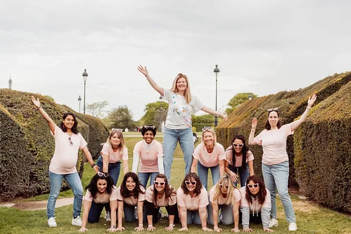 groupe de femmes formant une pyramide humaine dans un jardin à paris pendant un evjf joyeux et amusant