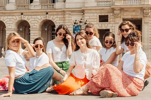 groupe de femmes assises en plein soleil devant le palais royal à paris pendant un evjf