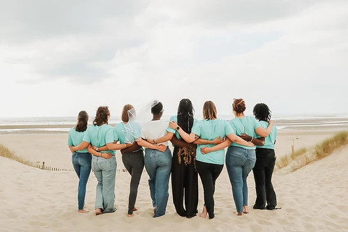 groupe de femmes en tee shirts turquoise de dos dans les dunes