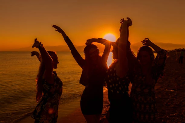 femmes qui trinquent avec des shooters groupe de femmes celebrant un evjf au touquet paris plage au coucher du soleil sur la plage
