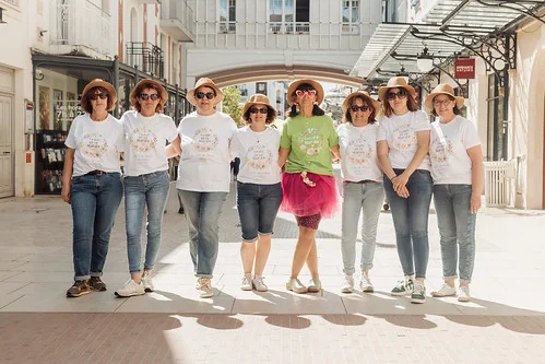 groupe de femmes en t shirt blanc et chapeau posant dans une rue du centre ville d arcachon pendant un evjf