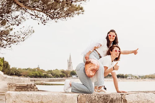deux femmes rient et posent face à la mer lors dun evjf à la rochelle avec des ballons en forme de cœur