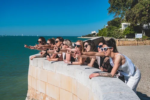 groupe de femmes regardant la mer et riant lors dun evjf à la rochelle par une journée ensoleillée