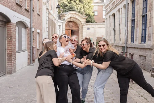 groupe de femmes riant ensemble dans une rue de lille pendant des gages et défis evjf