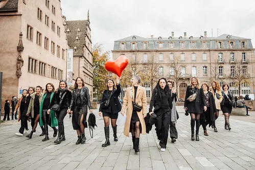 groupe de femmes marchant ensemble à strasbourg pendant un evjf avec un ballon rouge en forme de coeur