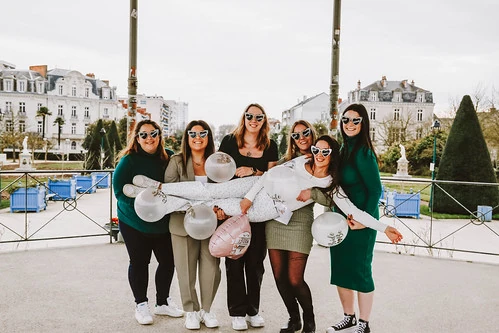 groupe de femmes celebrant un evjf a angers avec des ballons et des lunettes assorties pendant des gages et defis evjf angers