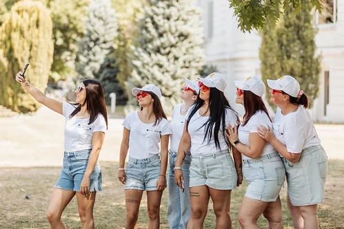 groupe de femmes en tenue blanche prenant un selfie pendant un evjf à annecy