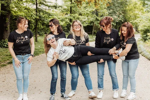 groupe de femmes riant lors d un evjf a bordeaux portant des t shirts team bride et soulevant la mariee pendant les gages et defis
