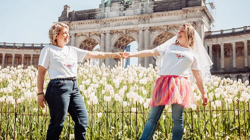future mariee en jupe rose tenant la main d une amie au parc du cinquantenaire a bruxelles pendant les gages et defis evjf