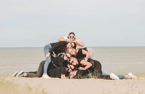 groupe de femmes empilees en pyramide riant sur la plage du touquet pendant un evjf et realisant des gages et defis