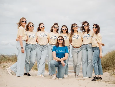 groupe de femmes en t shirt team bride posant sur la plage du touquet autour de la future mariee pendant les gages et defis evjf