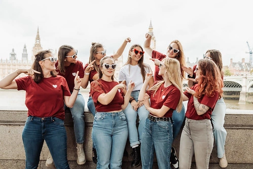 groupe de femmes en t-shirts rouges posant ensemble à londres pour des gages et défis evjf londres avec big ben en arrière-plan