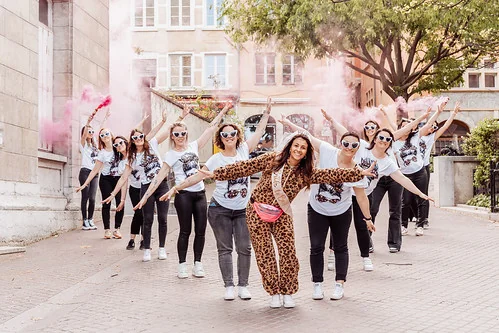 groupe de femmes celebrant un evjf a lyon avec fumigene rose et tee shirts assortis