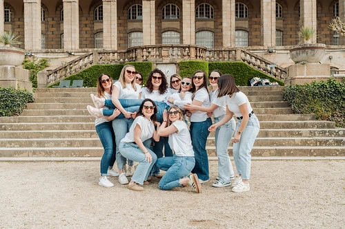 groupe de femmes participant à des gages et défis evjf à rennes posant sur de grands escaliers en plein air