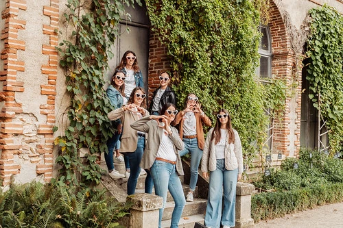 groupe de femmes posant devant un bâtiment couvert de végétation lors de gages et défis evjf tours