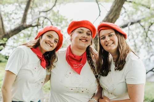trois femmes souriantes portant un béret rouge pendant un koh lanta evjf à biarritz