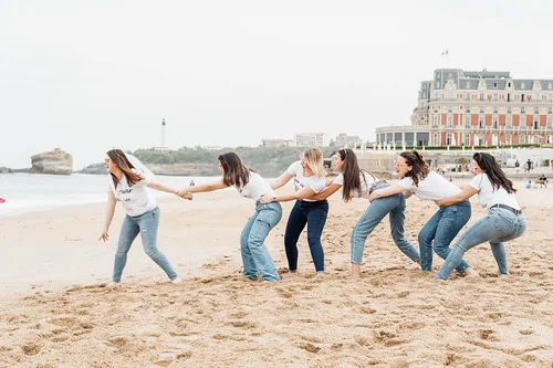 groupe de femmes jouant à tirer une corde sur la plage
