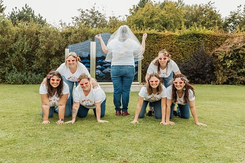 groupe de femmes formant une pyramide humaine sur une pelouse avec la future mariée voilée lors d’un koh lanta evjf à caen