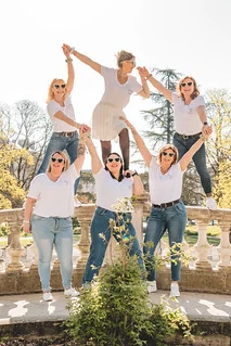 groupe de femmes celebrant un evjf a dijon dans un parc levant les bras pour illustrer les escape game evjf a dijon