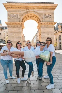 groupe de femmes celebrant un evjf a dijon posant devant la porte guillaume illustrant les escape game evjf a dijon