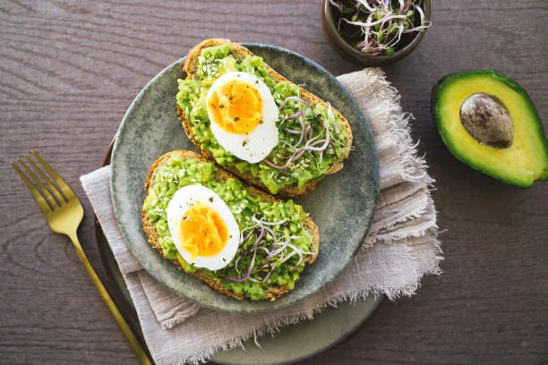 toasts a l avocat et oeuf mollet sur assiette en ceramique pour illustrer les meilleurs brunchs pour un evjf a dijon